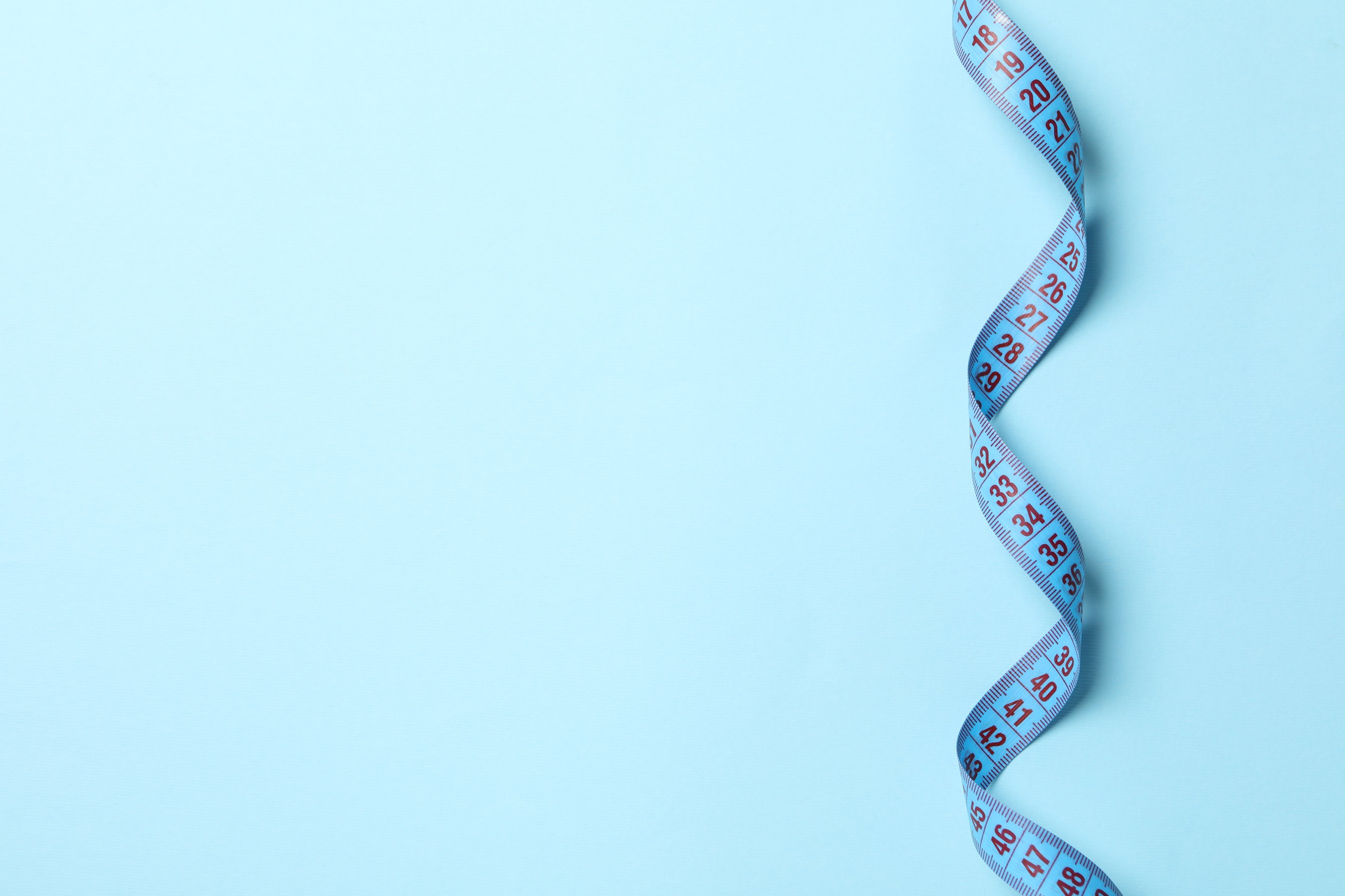 Measuring Tape on Blue Background. Weight Loss Concept